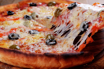 Pizza with cheese on board and wooden table background