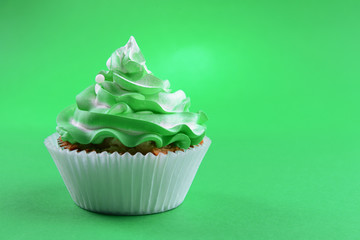 Delicious cupcake on green background