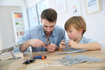 Father and son assembling airplane mock-up