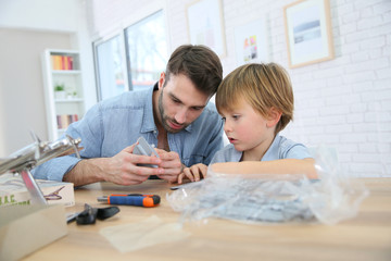 Father and son assembling airplane mock-up