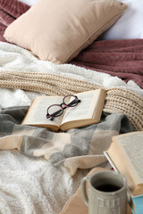 Book and glasses on bed close-up