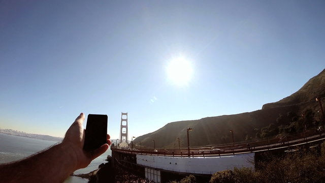 Person Smart phone technology image sun flare Golden Gate Bridge San Francisco