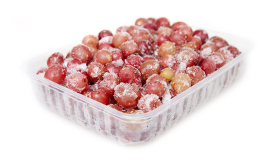 Frozen gooseberry in a plastic container on a white background.