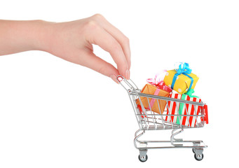 Female hand with small shopping cart full of gifts, isolated
