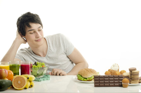 Man choosing between fruits, smoothie, healthy food and sweets