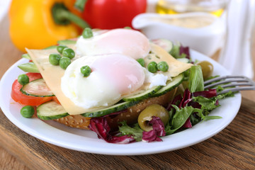 Sandwich with poached eggs, cheese and vegetables