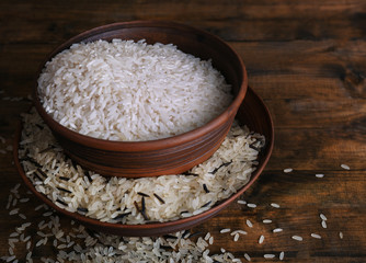 Fototapeta na wymiar Grains of rice in bowls on wooden background