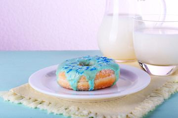 Glazed donut with glass and jug of milk