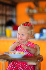 little toddler girl eating breakfast in cafe