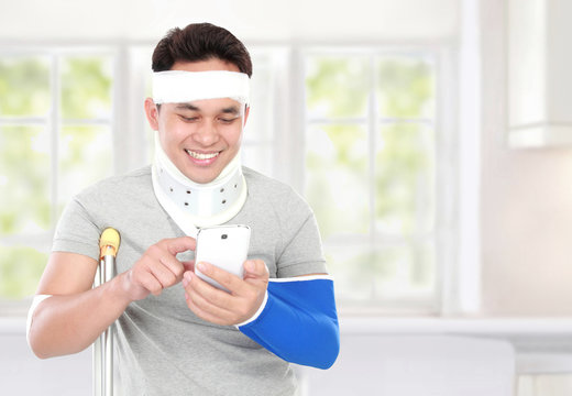 injured young man look happy play smartphone