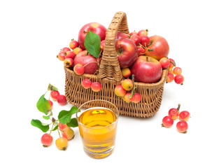 ripe apples in a wicker basket and a glass of juice isolated on