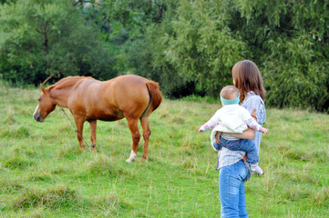 Young Mother with her baby girl watching the nature