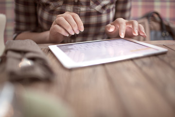 Woman in cafe typing on touch pad