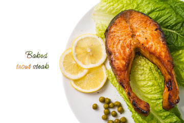 Top view of a baked trout steak with lemon and lettuce. Space fo
