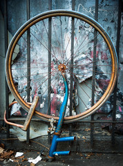 abandoned blue bicycle wheel on grungy background