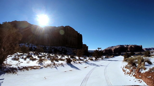 POV vehicle driving road Monument Valley winter snow blue sky Arizona USA