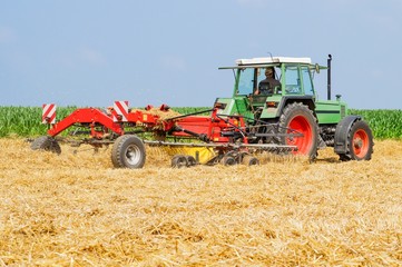 Obraz premium Traktor beim Stroh wenden.