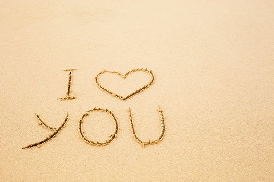  I love you written on wet yellow beach sand