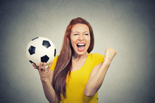 excited woman celebrating team success holding football