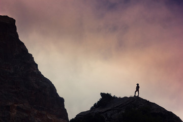 man on a cliff in mountains