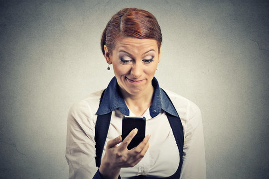 displeased young businesswoman reading bad news on smart phone