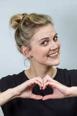 young woman making heart symbol