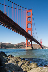 The Golden Gate Bridge with rocks in the foreground.