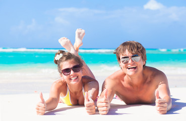 happy young couple lying on a tropical beach in Barbados