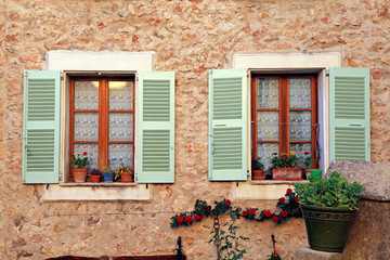 Fototapeta na wymiar french rustic windows with old green shutters, Provence
