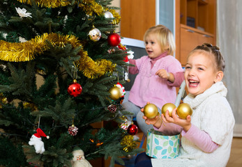 Fototapeta na wymiar Happy children decorating a fir