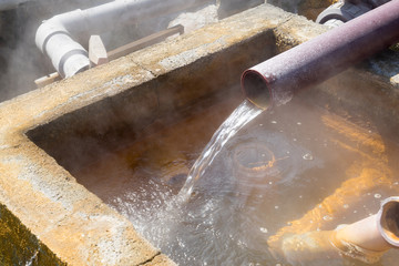 Hot water flowing out of pipe, hot spring water boiling
