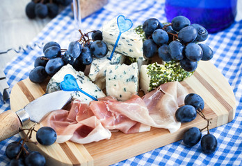 Appetizer with cheese, ham and grape