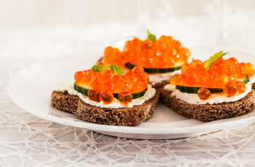 Heart shaped toasts  with red caviar and white wine