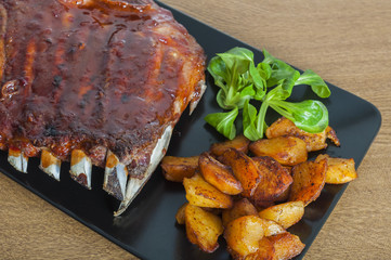 Barbecued honey ribs served with potatoes
