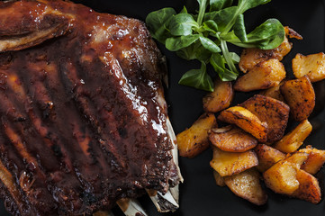 Barbecued honey ribs served with potatoes