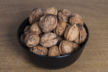 Walnuts in a bowl on wooden table