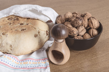 Bread, nutcracker and walnuts in a wooden table