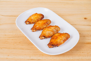 Plate of chicken wings spicy on wooden table.