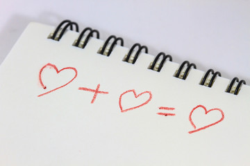  drawing heart on white notebook