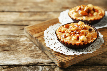 Mini cakes with nuts on wooden background