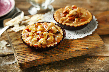 Mini cakes with nuts on wooden background