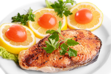 Tasty baked fish on plate isolated on white