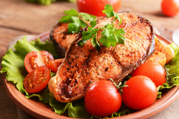 Tasty baked fish on plate on table close-up
