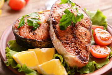 Tasty baked fish on plate on table close-up