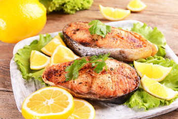 Tasty baked fish on plate on table close-up