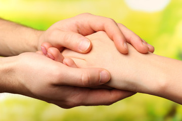 Male and female hands on bright background