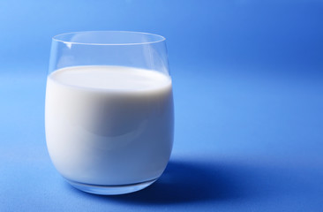 Milk in glass on blue background