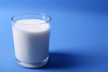 Milk in glass on blue background