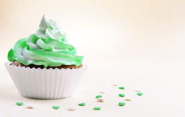 Delicious cupcake on beige background