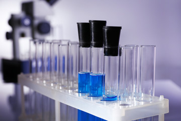 Laboratory glassware with blue liquid on gray background